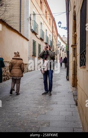 Un touriste masculin prenant des photos dans la rue historique de la ville de Ségovie, en Espagne Banque D'Images