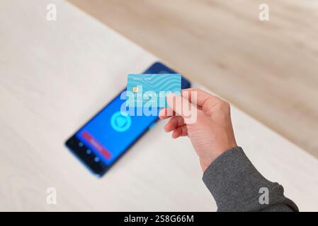 Carte de crédit survolant un terminal de point de vente avec une icône de paiement sans contact lumineuse, illustrant la technologie de paiement NFC moderne et des transactions transparentes Banque D'Images