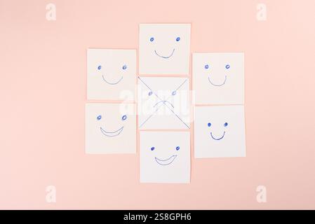 Cartes blanches avec une émotion triste barrée entourée d'émotions positives placées sur fond rose doux, concept de positivité. Banque D'Images