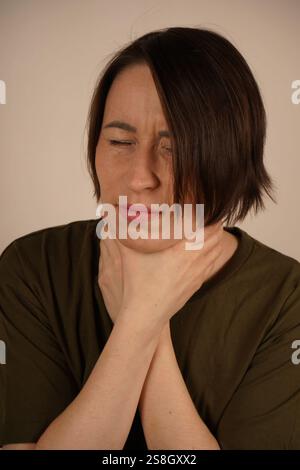 Maux de gorge. Libre de belle jeune femme effleure sa main mauvais Cou. Concept de la santé. Banque D'Images