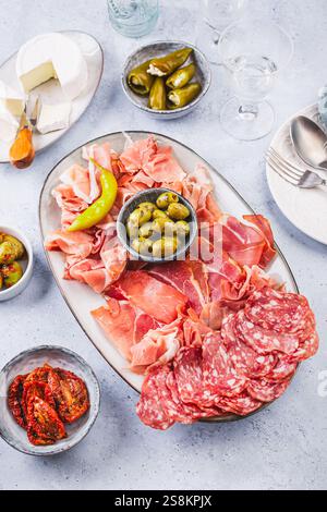 Assortiment de salami, jambon serrano et assiette de fromage avec olives et hors-d'œuvre Banque D'Images
