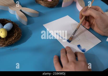 Peinture lapin DE PÂQUES préparation durable processus de bricolage de fabrication de cartes de voeux faites à la main. Activité étape par étape pour les enfants. Passe-temps inclusif et responsable de vacances de soulagement du stress. Célébration consciente Banque D'Images