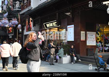 Shanghai, Chine. 21 janvier 2025. Un touriste ukrainien prend des photos dans la zone commerciale du jardin Yuyuan à Shanghai, dans l'est de la Chine, le 21 janvier 2025. Selon l'Administration municipale de la culture et du tourisme de Shanghai, Shanghai a reçu environ 6,7 millions de voyages entrants en 2024, en hausse de 84 % en glissement annuel. Crédit : Chen Aiping/Xinhua/Alamy Live News Banque D'Images