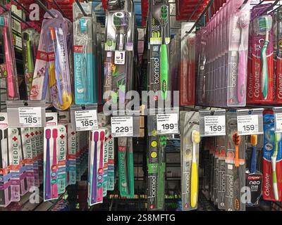 Variété de brosses à dents sur les étagères des magasins avec les prix affichés. Banque D'Images