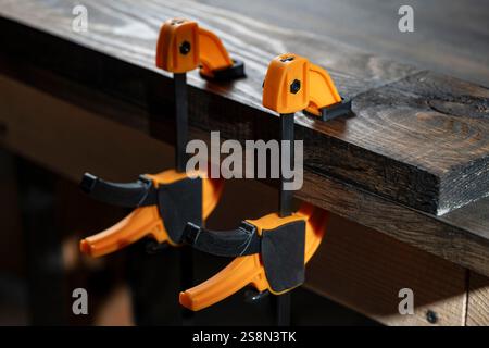 Charpentier deux pinces sont fixées aux planches, gros plan. Outils de menuiserie dans l'atelier de la maison Banque D'Images