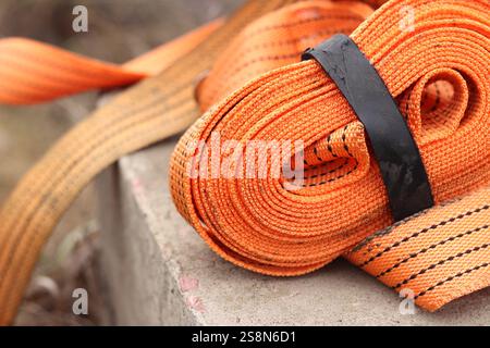 Sangles d'arrimage. Sangle de remorque en nylon orange et attache métallique. Gros plan d'une sangle de retenue de charge. Sangle d'arrimage de l'espace de chargement. Attache de chargement Banque D'Images