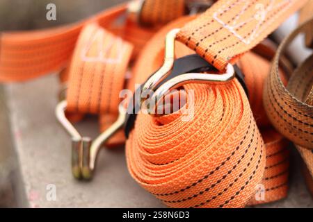Sangles d'arrimage. Sangle de remorque en nylon orange et attache métallique. Gros plan d'une sangle de retenue de charge. Sangle d'arrimage de l'espace de chargement. Attache de chargement Banque D'Images