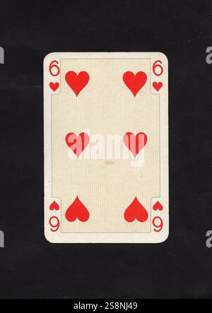 Une carte antique six de coeurs à jouer isolé sur un fond noir. Banque D'Images