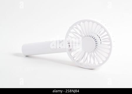 Mini ventilateur blanc électrique avec poignée isolée sur fond blanc. Banque D'Images