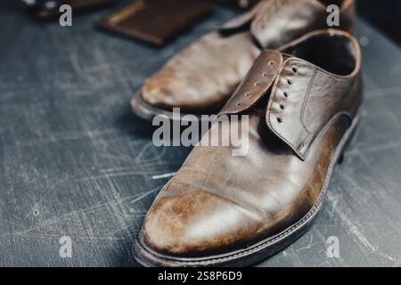 Gros plan de chaussures brunes vintage sur une surface rayée sombre Banque D'Images