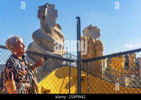 Touriste chevronné admirant les cheminées fantaisistes et l'architecture vibrante de casa mila, un site classé au patrimoine mondial de l'unesco à barcelone Banque D'Images