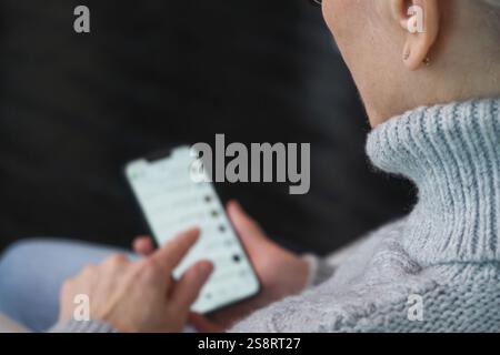 Femme senior choisissant des produits sur un smartphone pour la livraison à domicile Banque D'Images