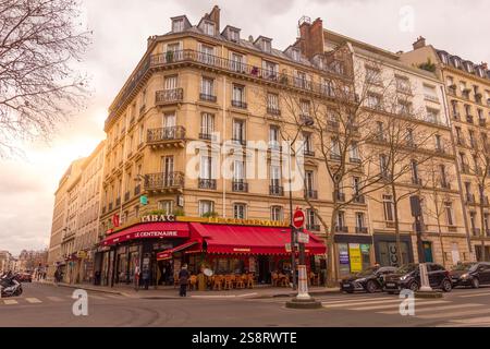 Paris, France - 5 mars 2023 : les gens dans un café français pendant le coucher du soleil. Paris abrite les grands restaurants de la gastronomie française. Banque D'Images