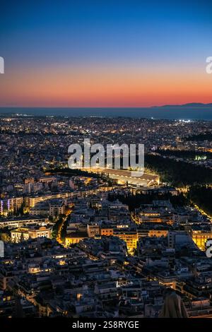 Vue verticale sur la ligne d'horizon illuminée d'Athènes, Grèce, avec le stade panathénaïque à Athènes, Grèce pendant le coucher du soleil. Ancien stade olympique Banque D'Images