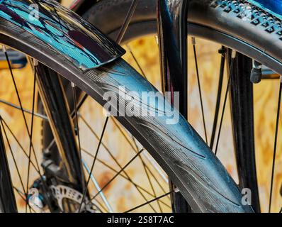 Explorer les détails complexes d'une roue de vélo dans un environnement urbain animé pendant la mi-journée Banque D'Images