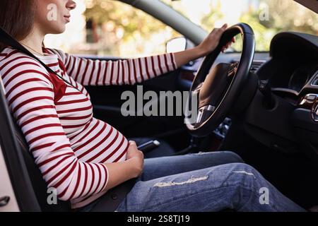 Femme enceinte avec ceinture de sécurité conduisant la voiture, gros plan Banque D'Images