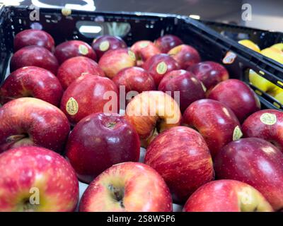 Pommes rouges fraîches empilées ensemble dans un présentoir d'épicerie Banque D'Images