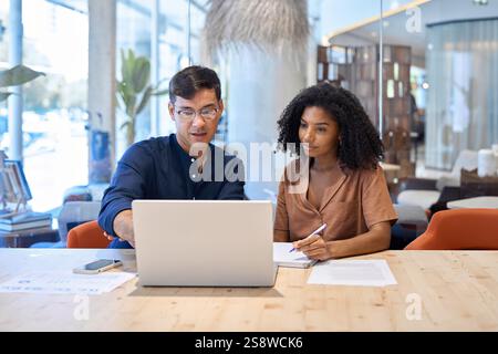 Employés professionnels de l'équipe occupée travaillant sur l'ordinateur lors de la réunion de bureau. Banque D'Images