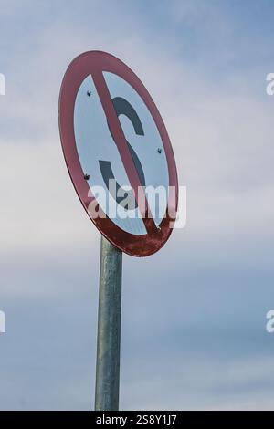 Gros plan d'un panneau de signalisation circulaire rouge et blanc avec un symbole « S » noir barré. Ce panneau indique une zone d'interdiction d'arrêt. Banque D'Images
