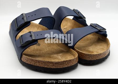 Paire de sandales Birkenstock Arizona bleu marine avec semelles en liège isolées sur fond blanc. Banque D'Images