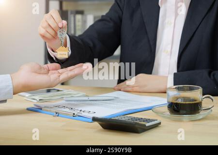 Agent immobilier donnant les clés de la maison au client après la signature du contrat immobilier d'accord avec le formulaire de demande de prêt hypothécaire approuvé Banque D'Images