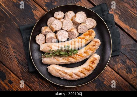 Saucisses grillées avec de la viande de forçage mincemat et des herbes dans l'assiette. fond en bois. vue de dessus. Banque D'Images