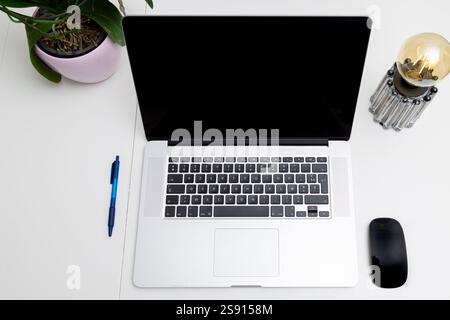 Espace de travail minimaliste avec ordinateur portable, stylet, souris et installation intérieure Banque D'Images