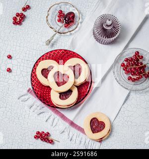 Biscuits en forme de cœur avec confiture rouge sur une assiette festive Banque D'Images