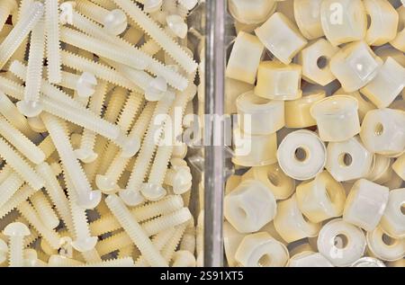 Écrous et boulons en nylon en plastique blanc boulonnerie de vis mécaniques accessoires divisés d'outils de travail. Banque D'Images
