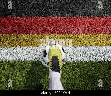 Plan d'un joueur de football debout sur le terrain avec un fond de drapeau allemand. Banque D'Images