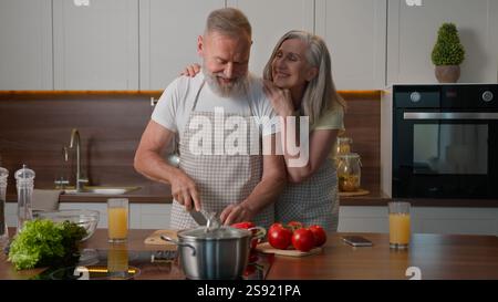 Caucasien Happy Old Family retraité d'âge moyen couple mature femme et homme aiment cuisiner ensemble à la cuisine à la maison couper des légumes frais nourriture saine Banque D'Images