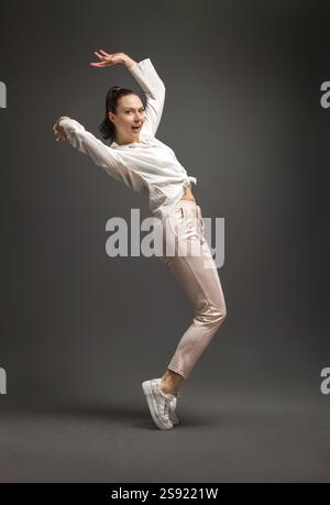 Junge und schoene Taenzerin posiert im Studio vor farbigem Hintergrund Banque D'Images