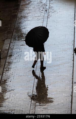 Vue d'en haut des personnes avec des parasols dans la rue un jour de pluie. Banque D'Images
