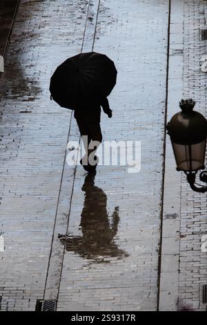 Vue d'en haut des personnes avec des parasols dans la rue un jour de pluie. Banque D'Images
