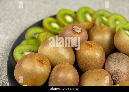 Assiette de kiwi frais tranchés et entiers. Banque D'Images