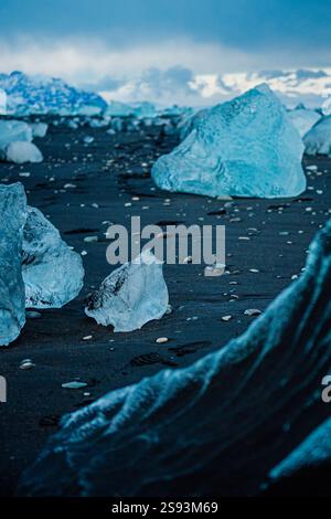 Fragments de glace glaciaire sur sable noir à Diamond Beach, au sud de l'Islande. Banque D'Images