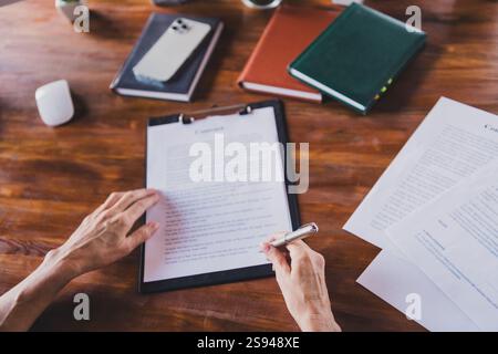 Vue à la première personne portrait d'une femme tenir le stylo signe document presse-papiers bureau centre d'affaires bureau à l'intérieur Banque D'Images
