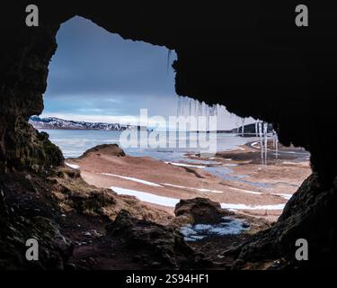 Vue depuis la grotte de Loftsalahellir avec les piles de mer de Reynisdrangar en arrière-plan, sud de l'Islande Banque D'Images