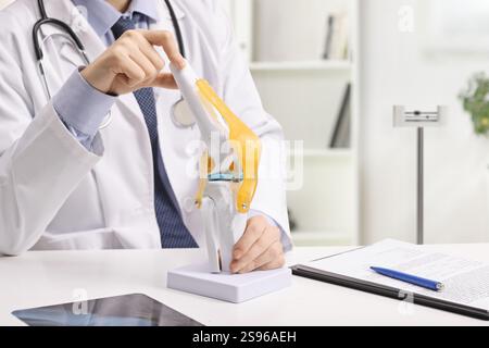 Le cabinet des médecins avec un modèle d'os du genou sur un bureau Banque D'Images