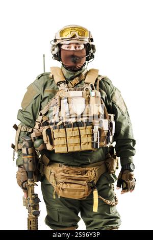 Un soldat en tenue tactique complète comprenant un casque, des lunettes et un gilet équipé, prêt à l'opération. L'image représente l'état de préparation et pr Banque D'Images