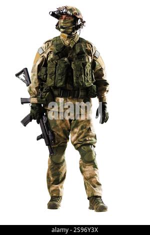 Un soldat en équipement tactique et camouflage, prêt pour une opération, tenant une arme à feu et portant un équipement avancé contre un dos blanc Uni Banque D'Images