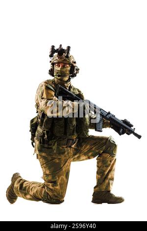 Représente un soldat en uniforme de camouflage et en équipement, accroupi, tenant une arme, placé sur un fond blanc propre pour un contraste élevé, mettant en valeur Banque D'Images
