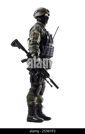 Une vue latérale pleine longueur d'un soldat tactique en pleine vitesse, tenant un fusil et préparé pour l'action, isolé sur un fond blanc. Banque D'Images