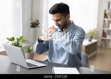Homme millénaire concentré communiquer en ligne avec une personne ayant une déficience auditive Banque D'Images