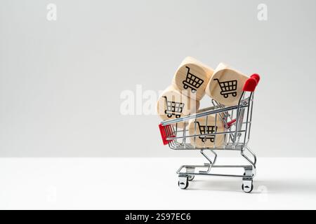 Bloc de cubes en bois avec des icônes de chariot dans le panier, concept de shopping en ligne, ventes, promotion, remise ou aubaine Banque D'Images