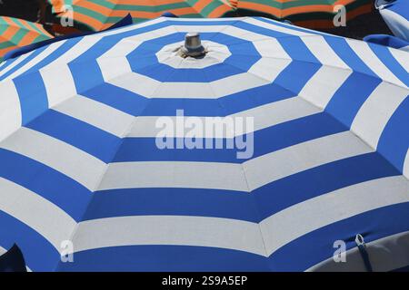 Vue en grand angle et gros plan du parasol de plage en toile blanche et bleue rayée, Monterosso, Cinque Terre, province de la Spezia, Italie, Europe Banque D'Images