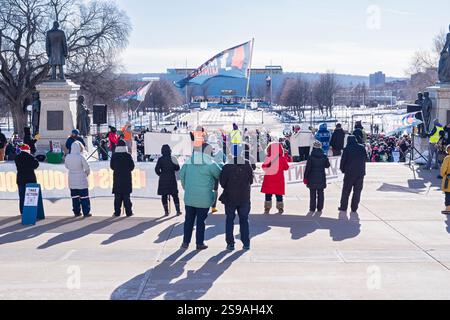 Paul, Minnesota - 18 janvier 2025 : le conférencier s'adresse à la foule alors que les partisans tiennent des bannières et des drapeaux pendant la marche du peuple au centre commercial State Capitol. Banque D'Images