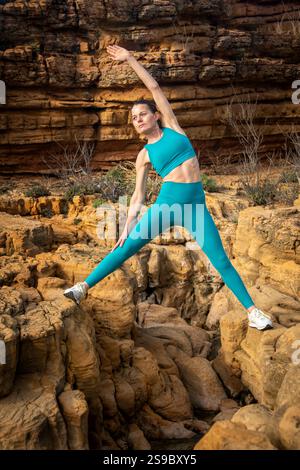 femme sportive faisant des exercices d'étirement sur les rochers Banque D'Images