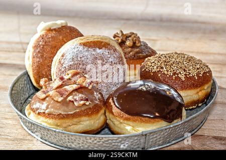 Plateau de beignets fourrés assortis avec diverses garnitures et glaçage Banque D'Images