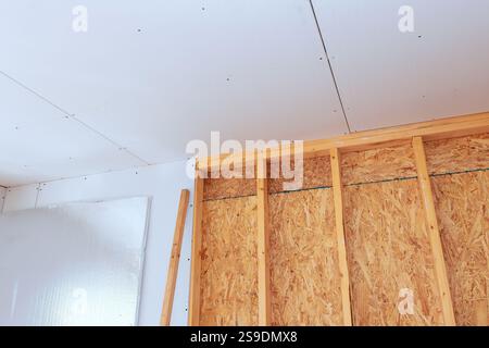 Les travailleurs assemblent, installent des cloisons sèches dans une nouvelle maison, exposant le bâtiment développant l'intérieur. Banque D'Images
